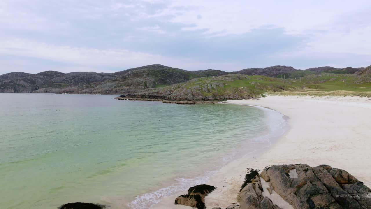Beautiful white sand and turquoise ocean waves rolling in to Achmelvich Beach