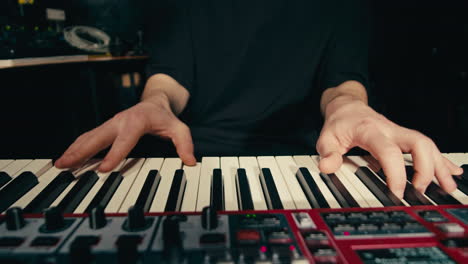 close up of keyboard player hands playing rock music with keyboard at the concert in studio, rehearsal room, macro play on synthesizer.