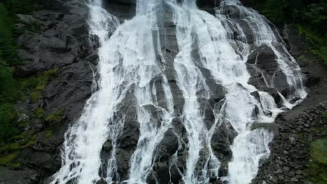 Drone-flies-over-a-road-and-up-a-waterfall