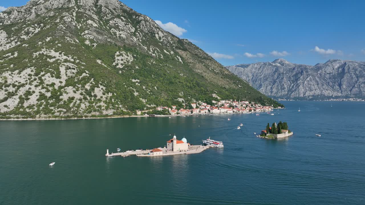 Aerial panoramic establishing of Our Lady of Mercy Monastery on a small island in the Bay of Kotor, Montenegro