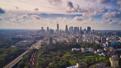 Morning-forwards-fly-above-city,-hyperlapse-of-busy-road-and-clouds-flowing-in-sky.-Skyline-with-tall-modern-office-buildings.-Warsaw,-Poland
