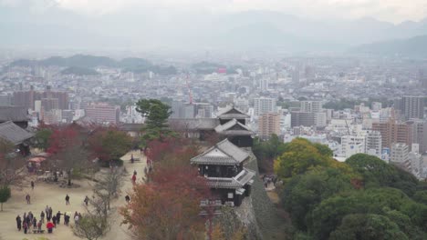 pan up over castle grounds of matsuyama castle with city in distance