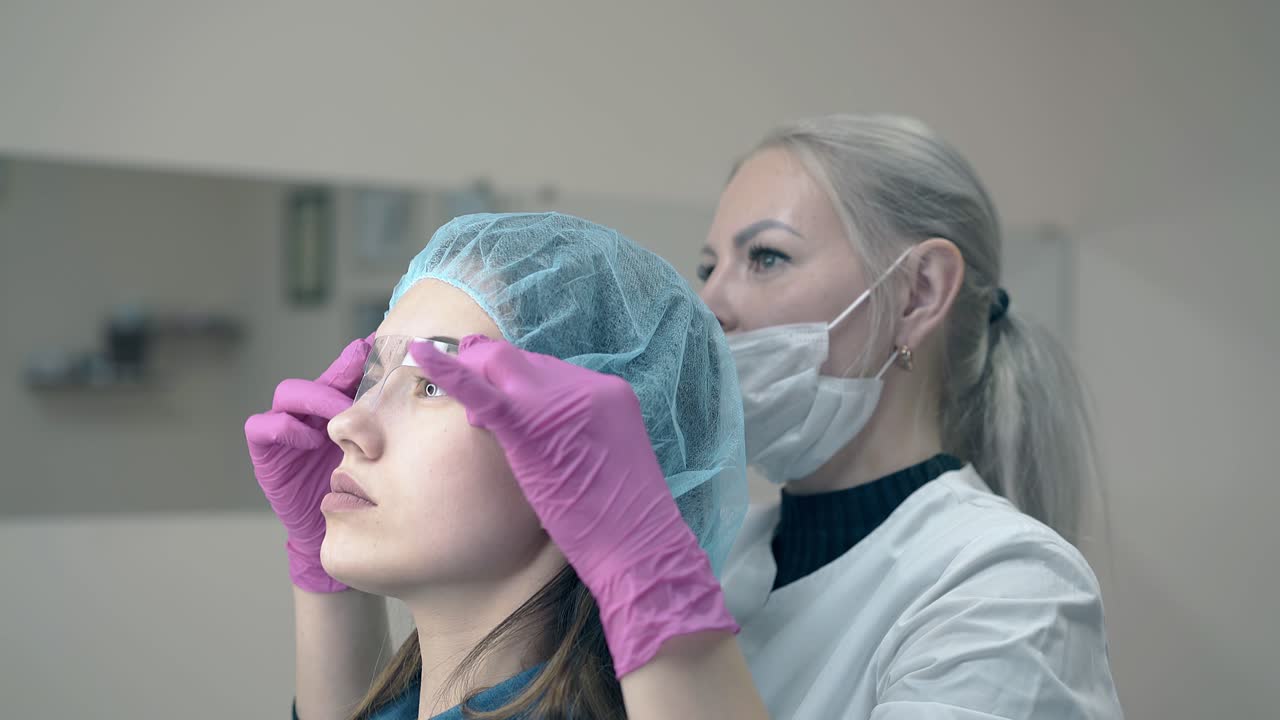 el cosmetólogo y el cliente usan una regla de cejas para comprobar el tatuaje.