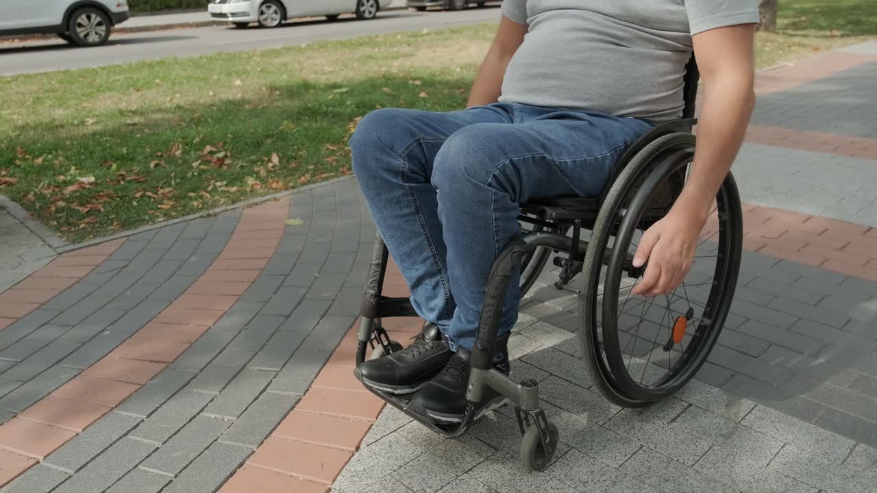 Man with disabilities in wheelchair walk at the park alley
