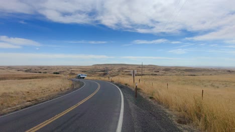 Semi-tractor-trailer-turning-onto-the-highway-and-driving-towards-the-camera-in-the-Scablands-in-Eastern-Washington-State