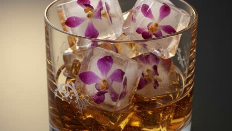 a captivating close-up of glass with decorative ice cubes and floral accents, perfectly highlighting a refreshing beverage in an elegant setting