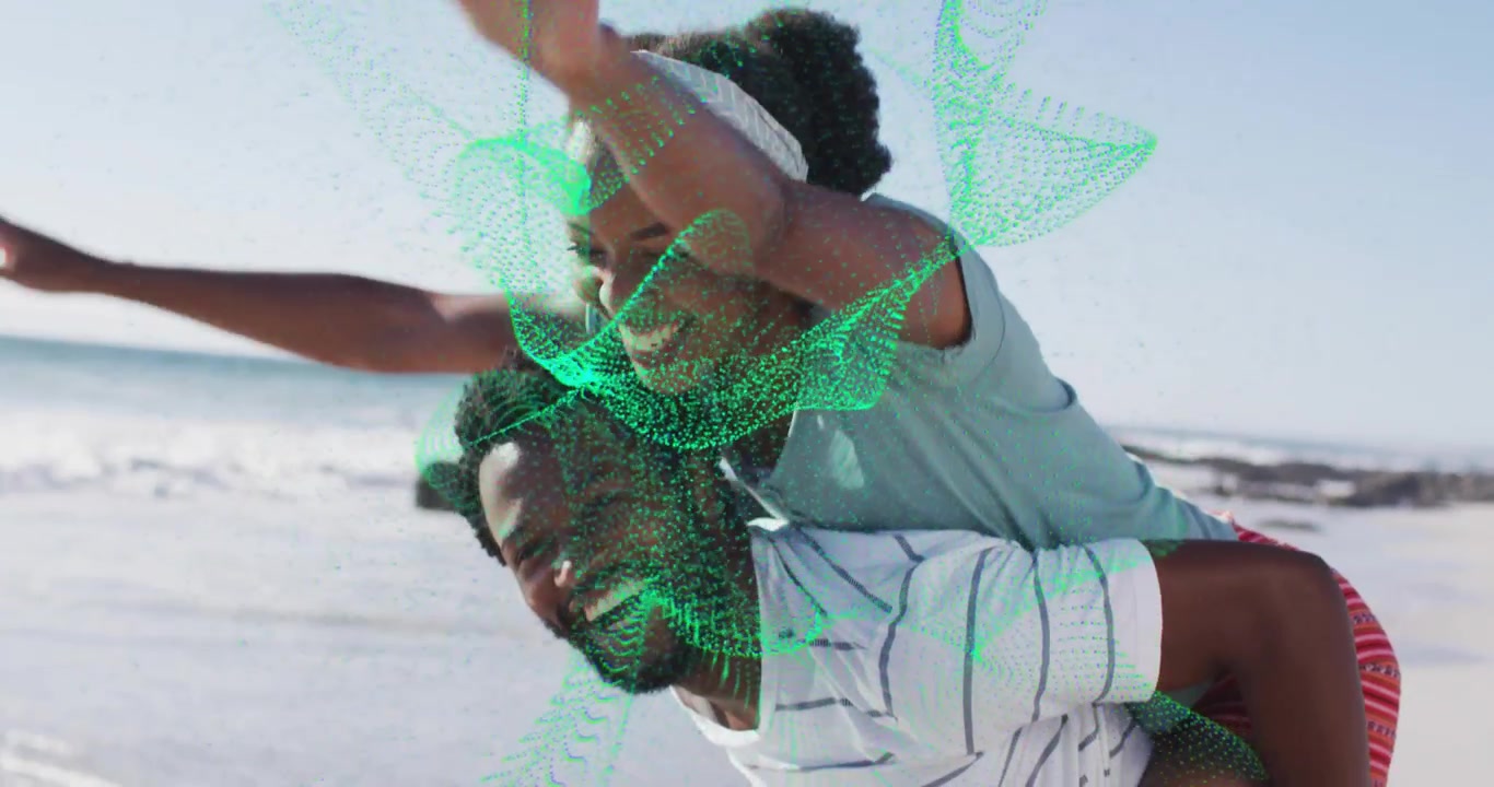 Couple playing piggyback on shore, woman gripping initiating lean, green tech mesh across them