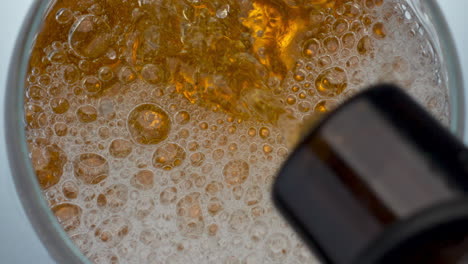 bottle pouring craft beer in glass closeup. lager stream making foam in drink