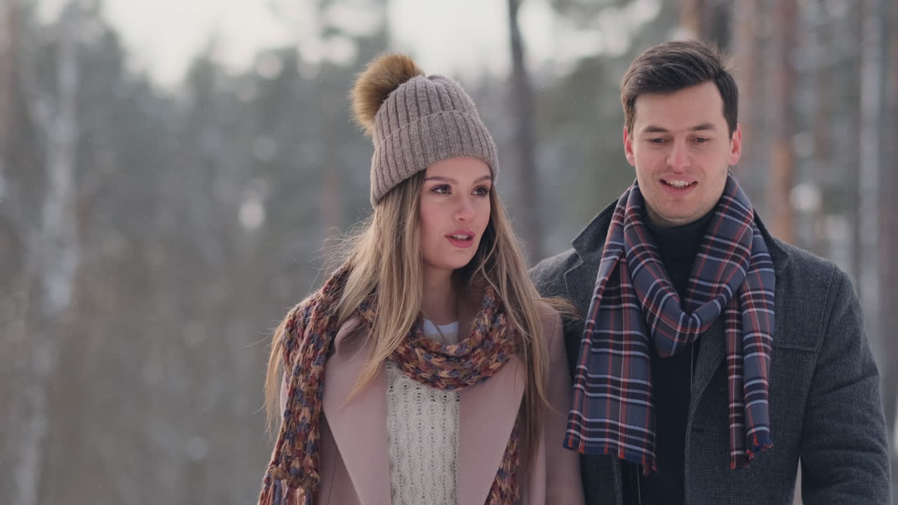 행복한 커플은 산에서 햇빛과 따뜻한 겨울 날씨를 즐기며 밖에서 겨울 게임을 하고 있습니다. 강한 소년이 여자친구를 어깨에 메고 빙빙 돌고 있다