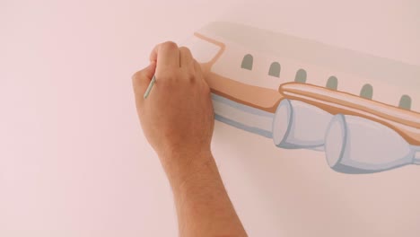 el artista está decorando las paredes con dibujos en la habitación de los niños. pintura de arte de las paredes en la casa nueva. trabajos de reparación.