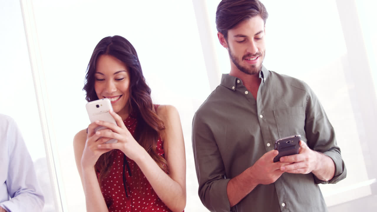 ejecutivos sonrientes usando el teléfono móvil