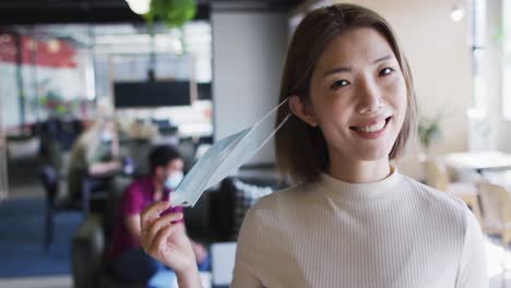 portrait of asian businesswoman looking at camera smiling in modern office