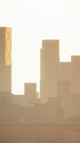 a beautiful cityscape at sunset, with tall buildings silhouetted against the golden sky.