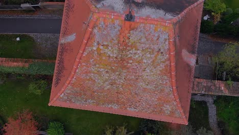 a drone descends over the roof of an old town watchtower