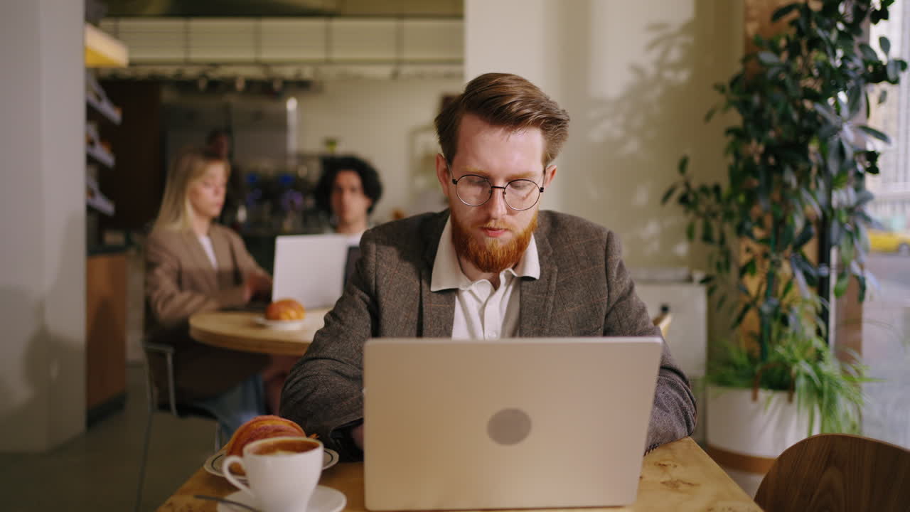 A man working on his laptop in a cafe