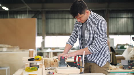 woodworker sanding a wooden plank in a workshop