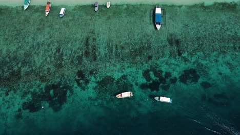 Holzboote-Auf-Klarem,-Blauem-Meerwasser-In-Küstennähe-In-Bali,-Indonesien