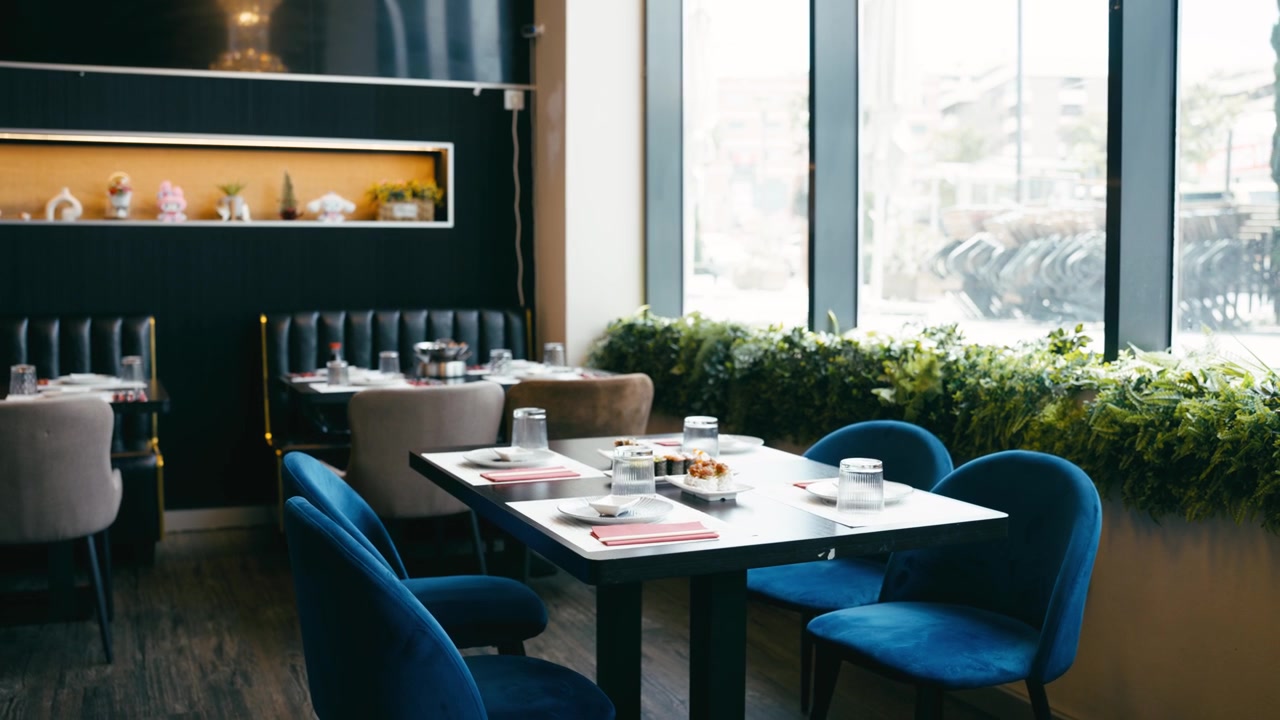 Interior de restaurante moderno con mesas puestas y grandes ventanales