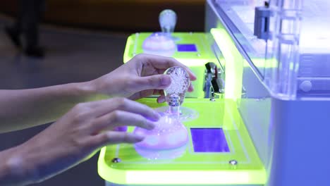 hands interacting with a glowing game machine