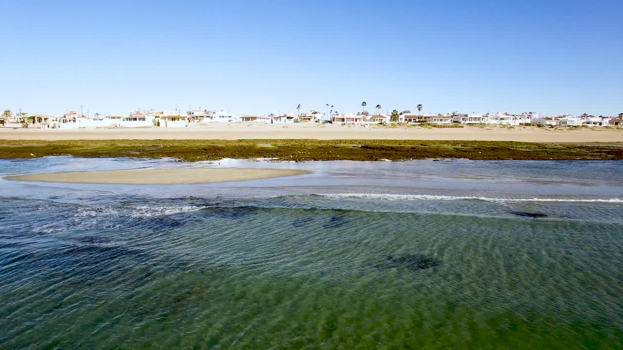 panorámica aérea a través de las olas entrantes durante la marea baja, punto rocoso, puerto peñasco, golfo de california, méxico