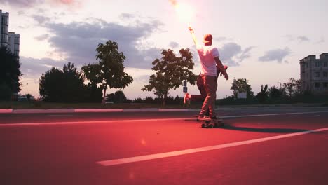 group of young people skateboarding on the road in the early morningwith red sugnal flare, slow motion