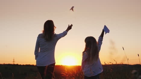 Mama-Und-Tochter-Starten-Papierflieger-In-Die-Luft