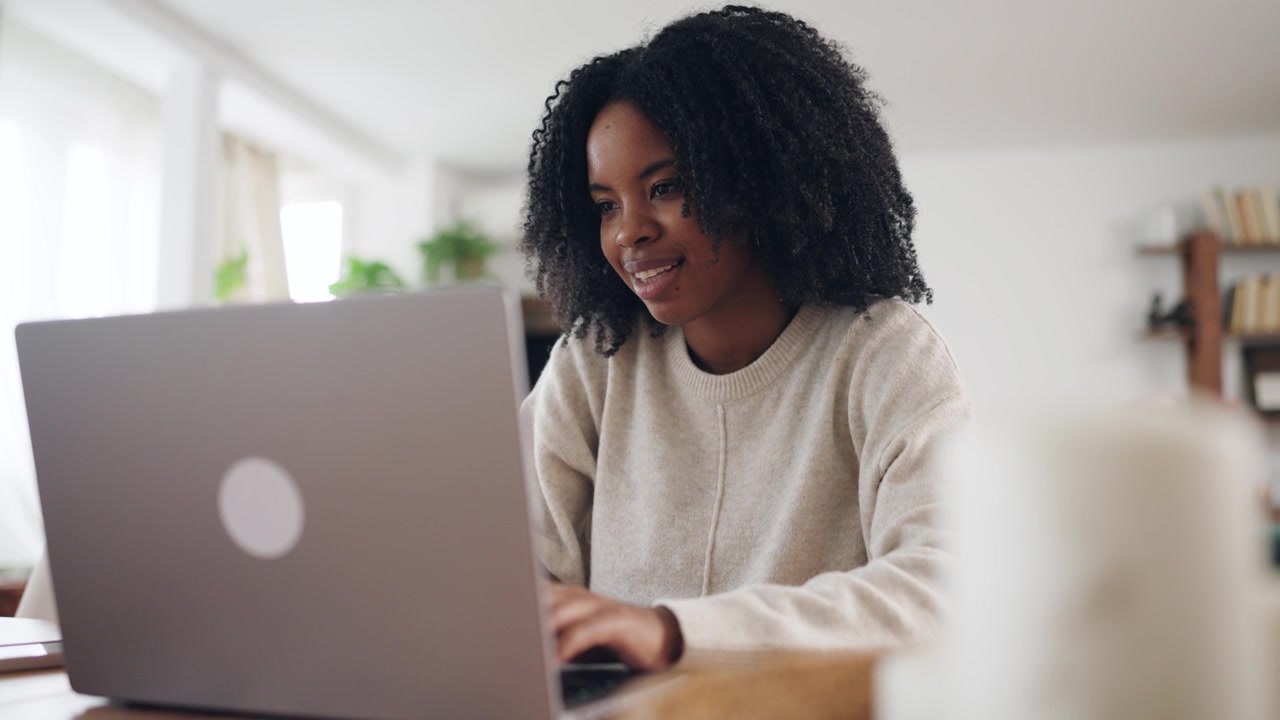 Happy Young Black Woman Typing on Laptop at Home