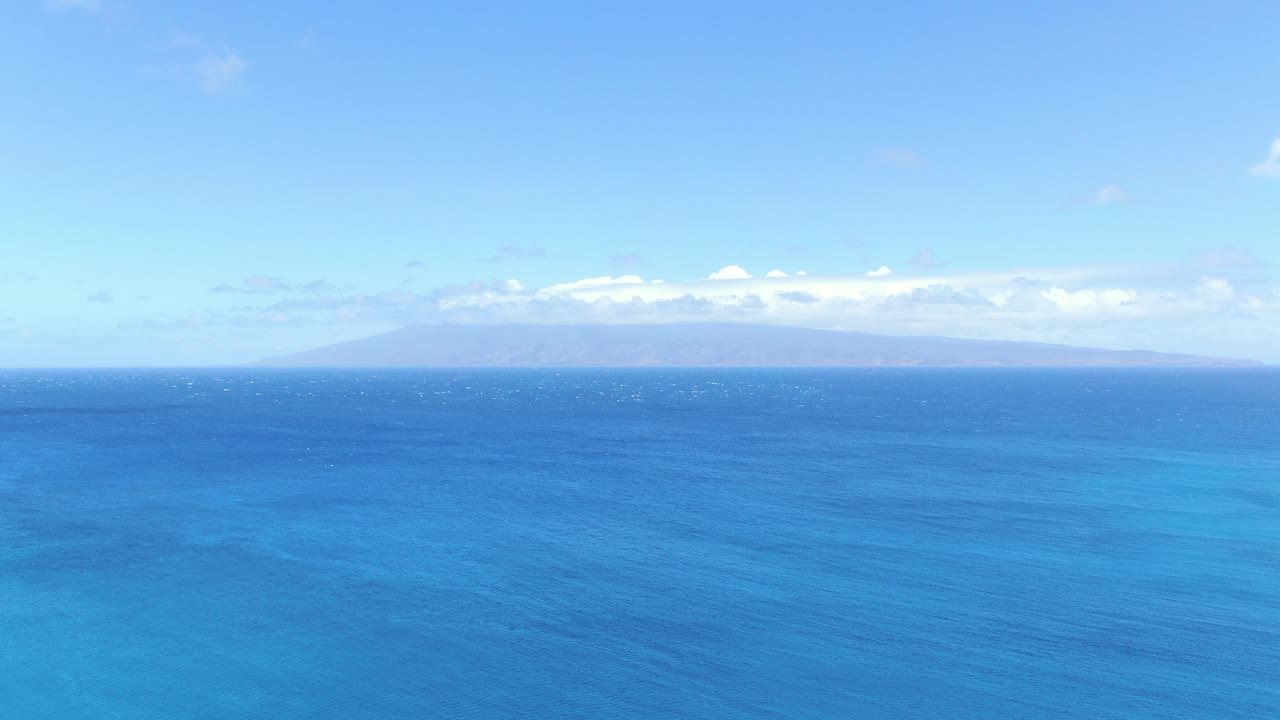 항공: 보그에 가려진 몰로카이를 바라보는 하와이의 깊고 푸른 바다 지평선