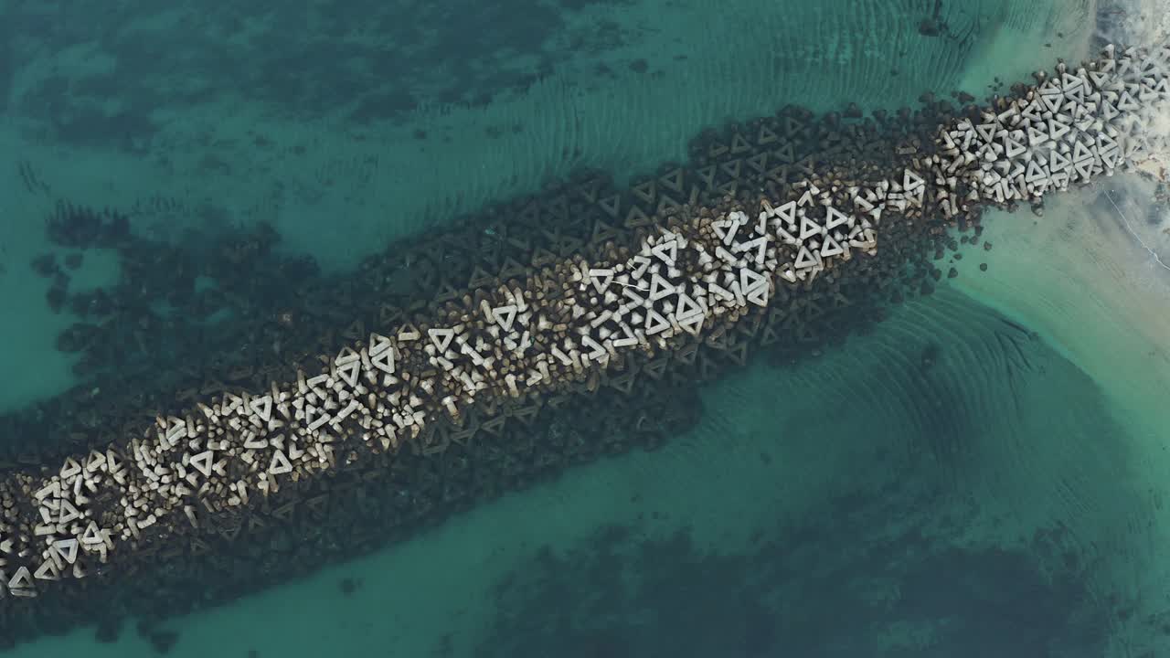 일본 야쿠시마의 활기찬 따뜻한 바다에서 방파제 테트라포드의 공중 전망