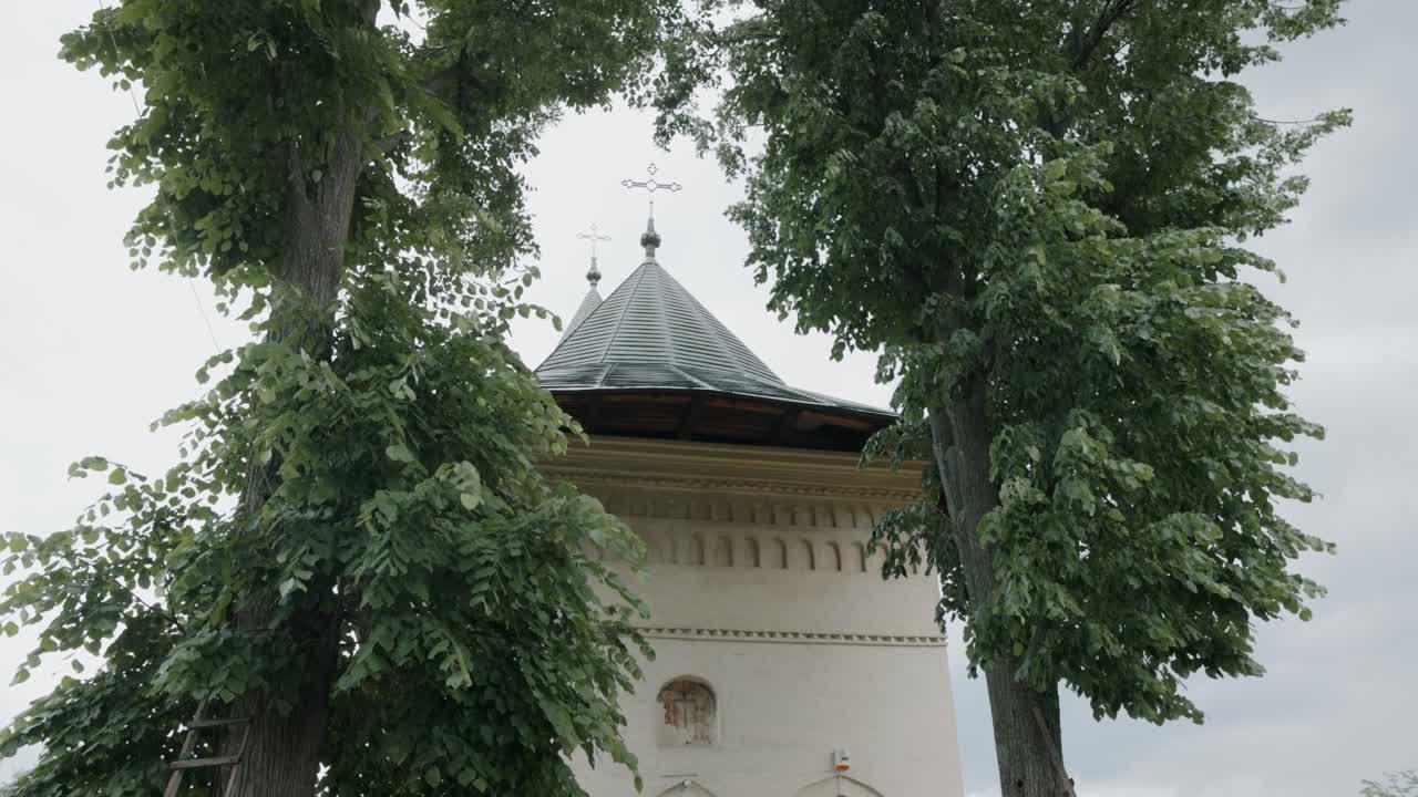 Orthodox Monastery Behind Trees In The Village Of Mera, Vrancea County, Romania. Low Angle Shot