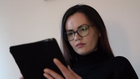 retrato de una joven seria usando una tableta, pantalla táctil, medios digitales