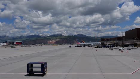 american airlines airplane at airport gate with mountains in background