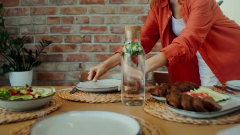 woman setting the table for a meal