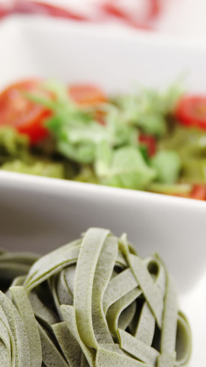 신선한 스파나치 페투치네 누들과  ⁇ 러드 그 ⁇ 이 테이블 위에 있습니다.