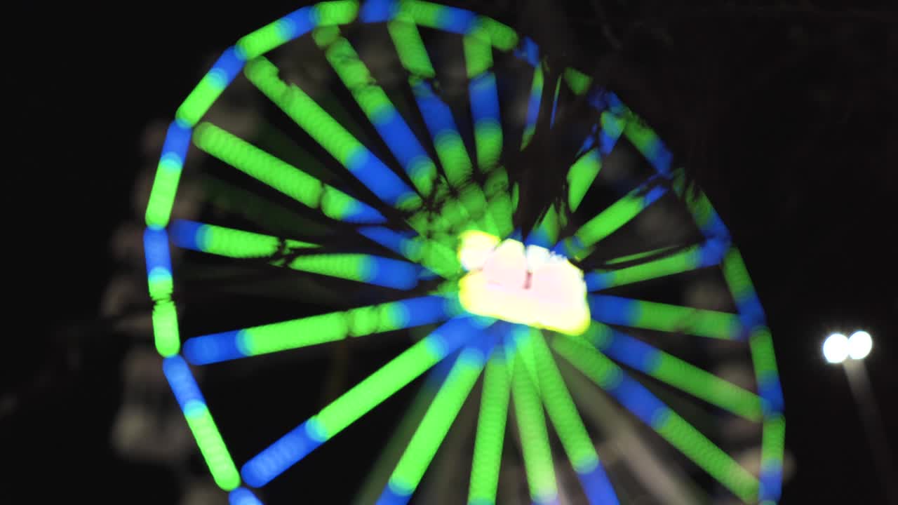 rueda de ferris desenfocada por la noche en un parque de atracciones