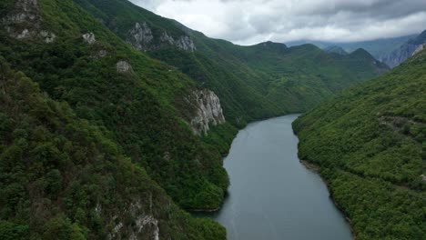 green mountain slopes of lake komani, overcast day, aerial dolly in
