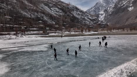 silhouette of ice hockey players on frozen khalti lake at ghizer valley