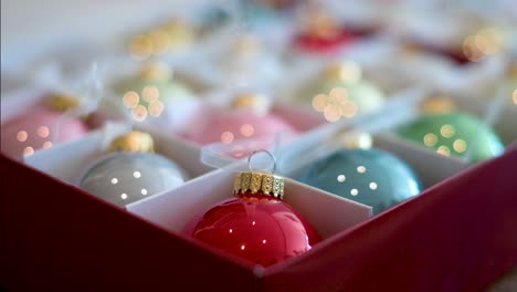 pinpointed focus on a radiant red christmas ornament, contrasting against the blurred hues of other colors in the box