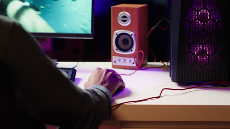 jugador que utiliza el teclado y el ratón para jugar a un videojuego en una pc de juegos