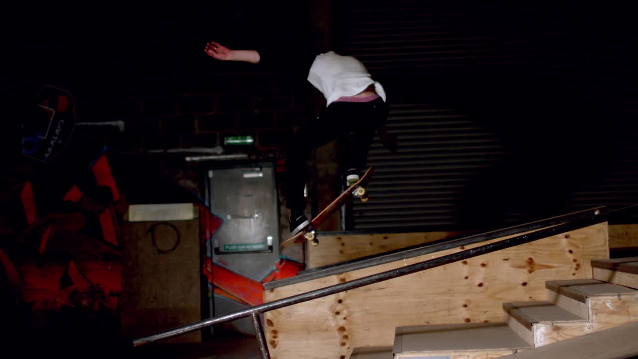 Pattinatore che esegue un ollie inclinato giù per le scale