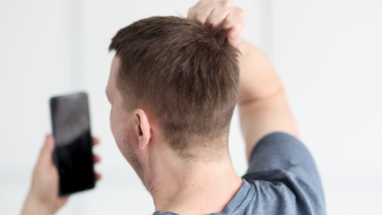 Giovane uomo che tiene in mano un telefono cellulare e urla