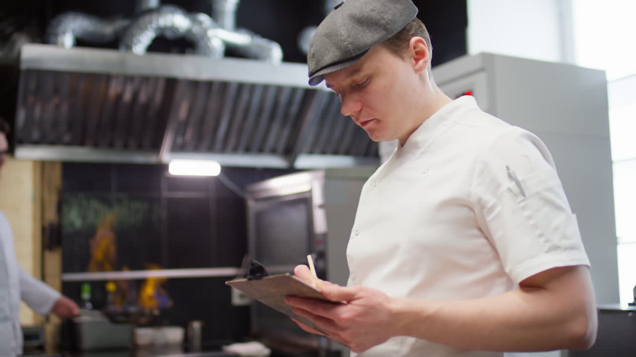 Chef Taking Notes while Working in Restaurant Kitchen