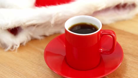 Close-up-of-coffee-cup-with-saucer-and-santa-hat