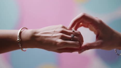 close-up shots of hands adorned with elegant rings and bracelets against a vibrant background