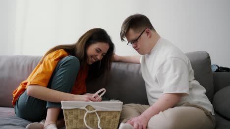 Sister-and-brother-together-at-living-room,-funny-activity,-inspecting-box-together-and-laugh