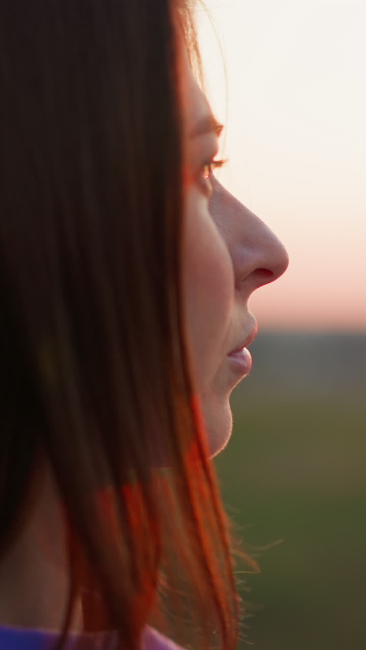 mujer tranquila en el parque de primavera al atardecer en primer plano. dama morena disfruta del paisaje inspirador en el campo del crepúsculo. turista pasa vacaciones en la naturaleza