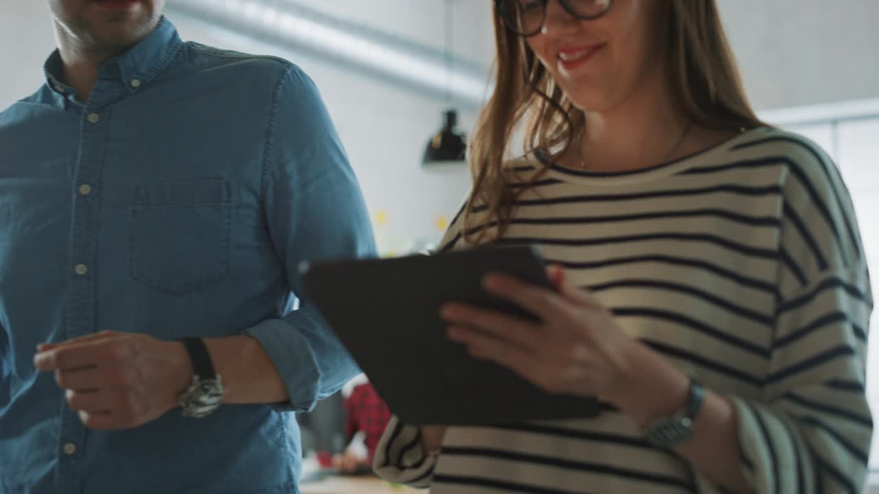 jóvenes mujeres y hombres colegas caminando por la oficina mientras tienen una discusión amistosa sobre nuevas ideas de negocio. atmósfera de coworking tranquila en la agencia creativa.