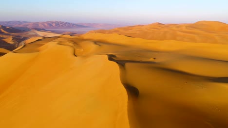 aerial view of a man sitting on the edge of dunes, u.a.e.