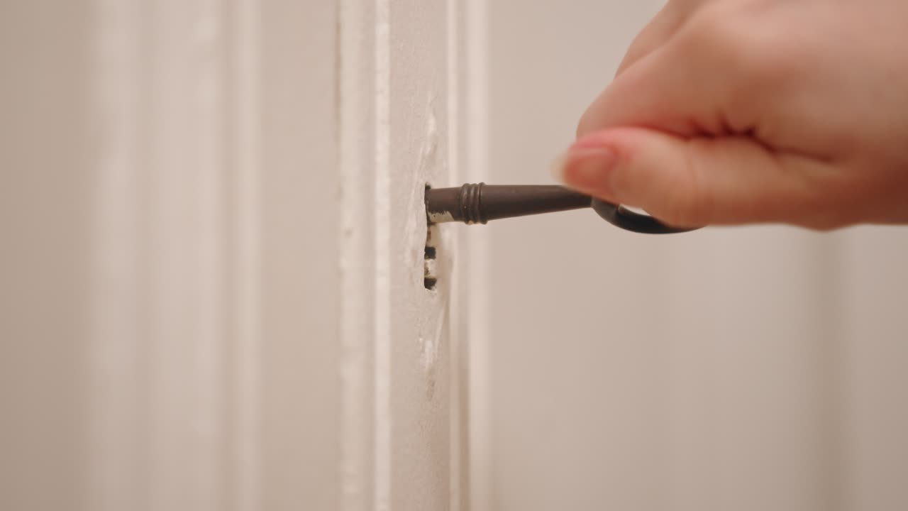 una persona está abriendo un armario usando una llave antigua