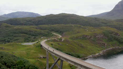 Toma-De-Drone-De-La-Carretera-Que-Conduce-Al-Puente-Kylesku-En-El-Noroeste-De-Escocia-Que-Cruza-El-Lago-A&#39;cairn-Bain-En-Sutherland